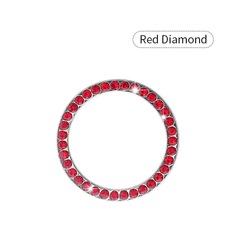 A circular crystal rhinestone start/stop button cover, set with red diamonds.