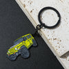 A yellow Ford Bronco zinc alloy keychain attached to a black ring, resting on a light wooden surface.