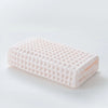 A rectangular pink waffle weave bath towel lying flat on a white surface.