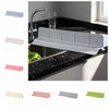 A set of flexible silicone sink splash guards in various colors, including silver, pink, and green, shown installed in a kitc