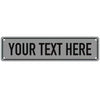 A rectangular gray metal sign with the text YOUR TEXT HERE engraved on it.