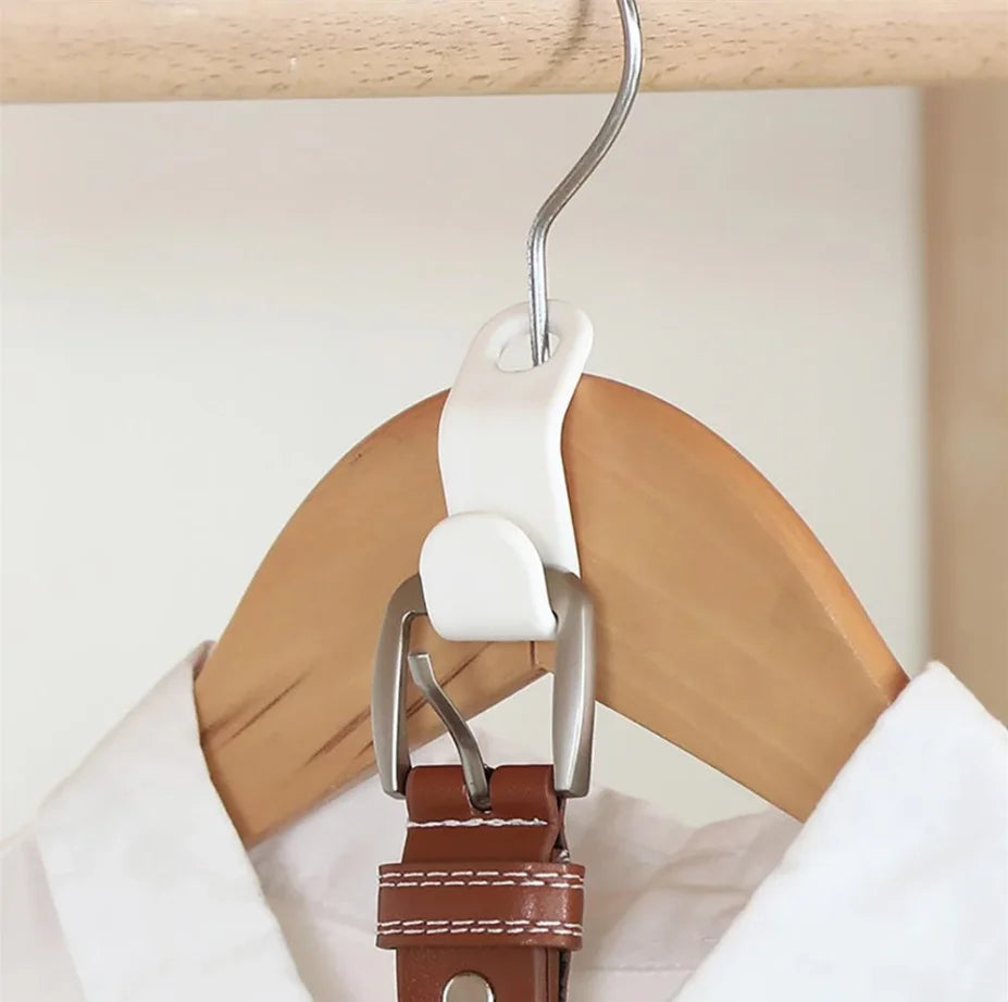 A close-up of a white hanger with a metal hook connector attached to a brown leather strap.