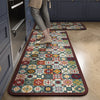 A rectangular patterned floor mat with geometric designs in various colors rests on a light wood floor.
