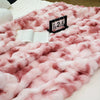 Pinkes Kunstfell-Kaninchen-Fleece-Decke liegt auf einer weißen Fläche mit einem schwarzen Marker, der den 25. September anzei