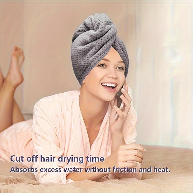 A woman is using a towel wrap on her hair while talking on a phone.