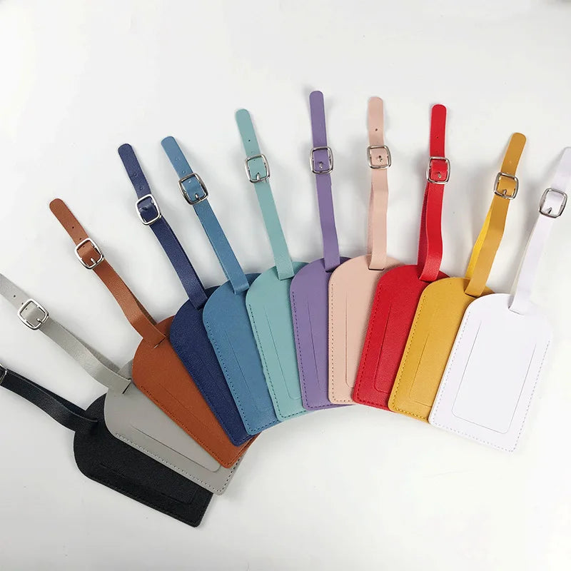 A collection of classic PU leather luggage tags in various colors including blue, green, purple, pink, red, yellow, and white