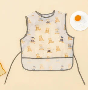 A light yellow waterproof baby feeding bib with a sleeveless design featuring small animal illustrations.