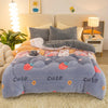 A soft blue and gray plush throw blanket decorated with strawberry and cloud patterns, displayed on a light-colored rug.