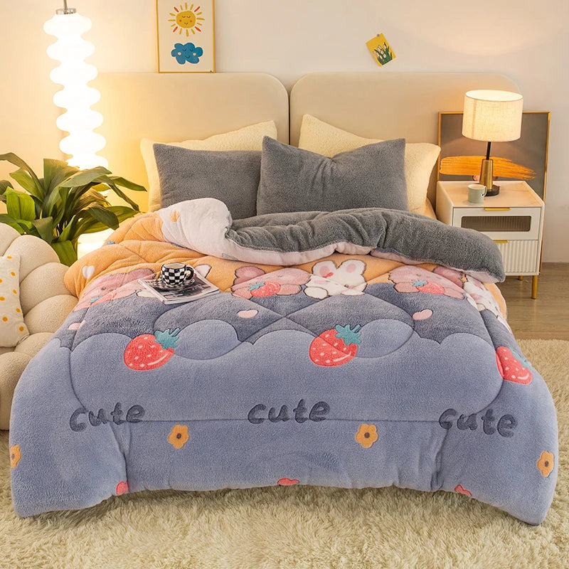A soft blue and gray plush throw blanket decorated with strawberry and cloud patterns, displayed on a light-colored rug.