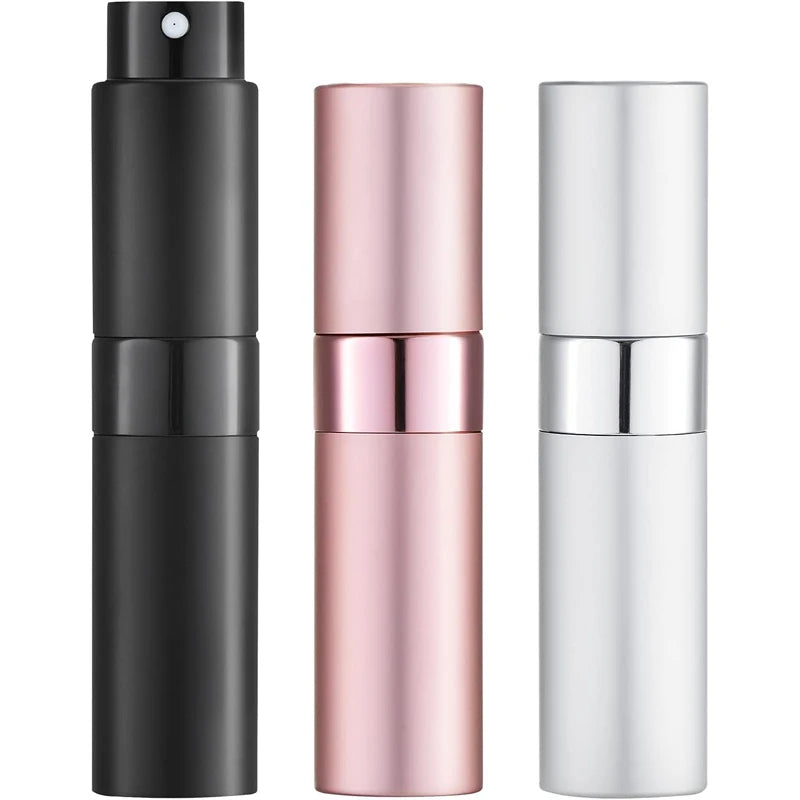 Un set de tres atomizadores de perfume para viajar en negro, oro rosa y plata.