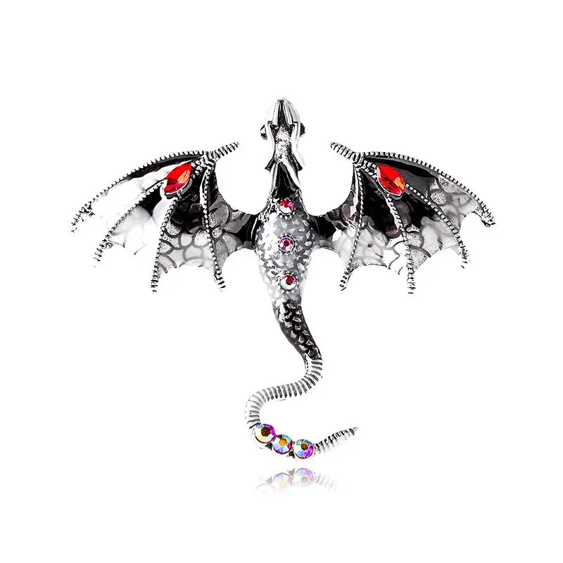 A detailed enamel dragon brooch featuring black and white scales with colorful rhinestone accents.