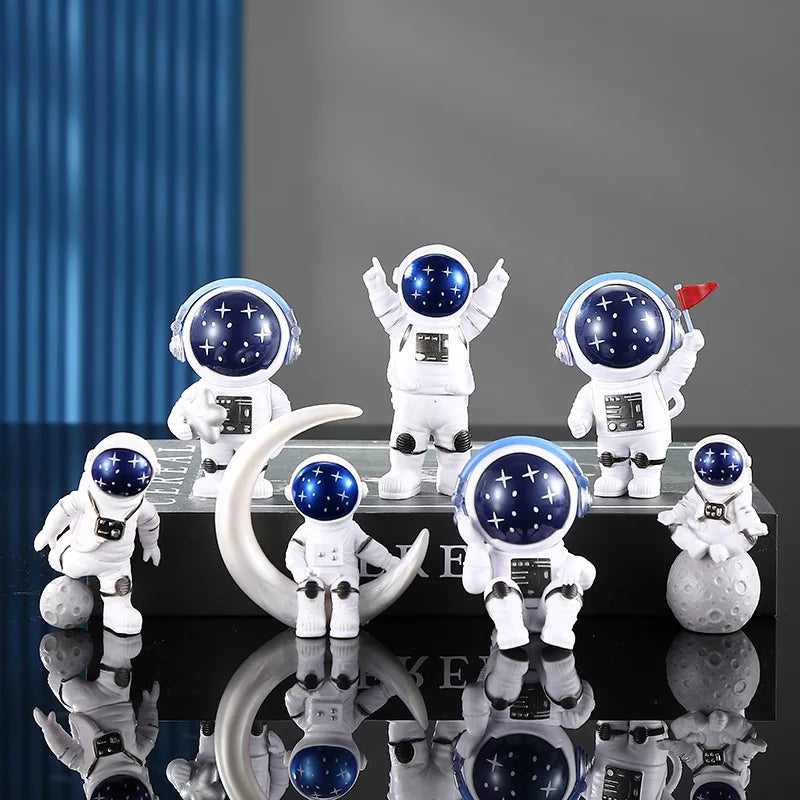 A collection of handcrafted astronaut figurine resin spacemen desk decor displayed on a dark surface.