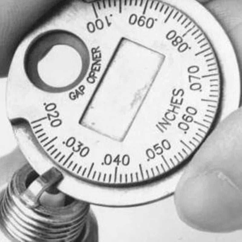 Close-up photo of a coin-type spark plug gap gauge showing measurements on the dial.