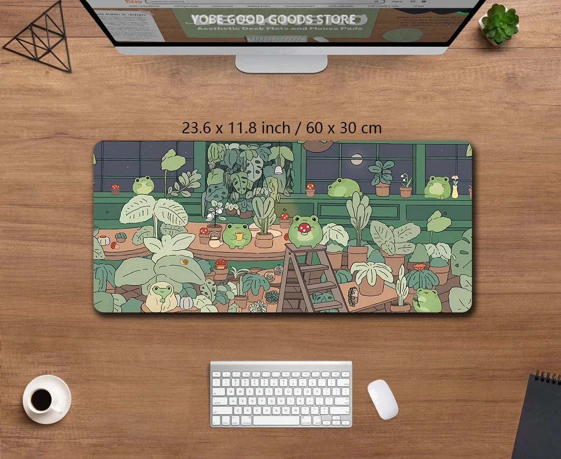 A large extended desk mat featuring a kawaii nature design of various green frogs and plants.