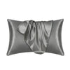 A smooth, gray satin pillowcase draped on a surface.