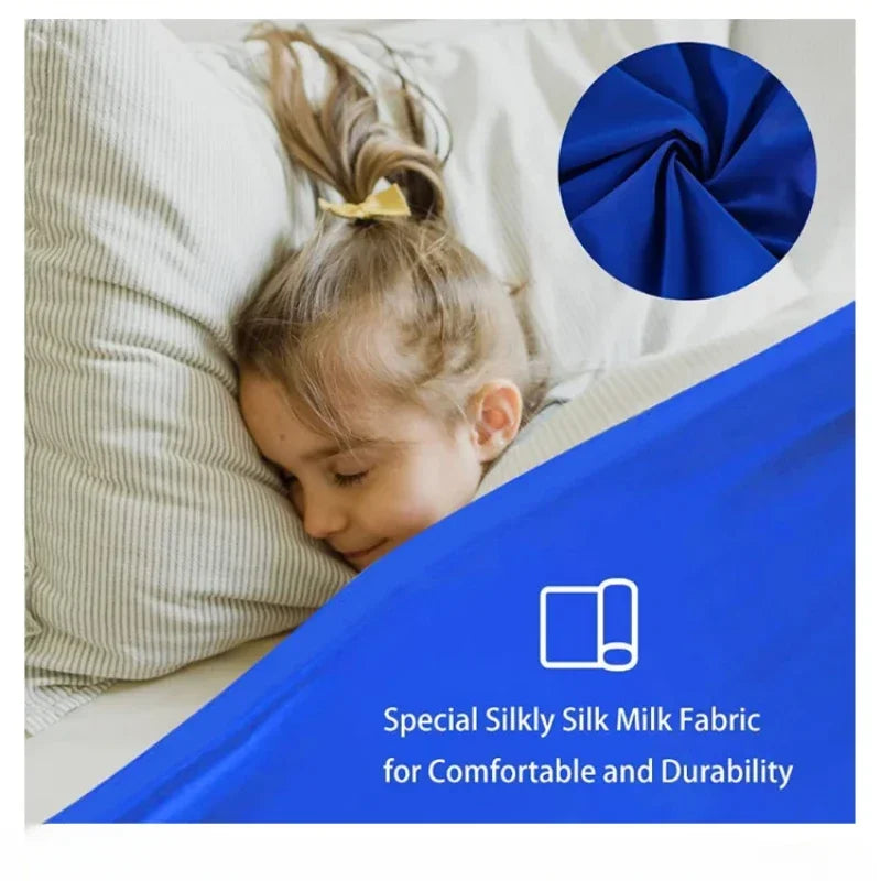 A child is resting on a bed with a blue fabric and a dark blue circular swatch of silk fabric.