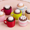 A collection of colorful ceramic mugs filled with chocolate mousse and topped with whipped cream.