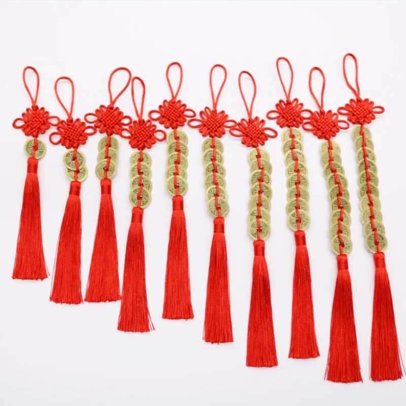 A set of red Chinese Feng Shui wealth coins with handmade knot tassels and green accents.