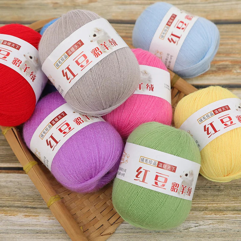 A collection of various colored fine yarn skeins for knitting and crochet, including red, gray, pink, purple, and yellow.