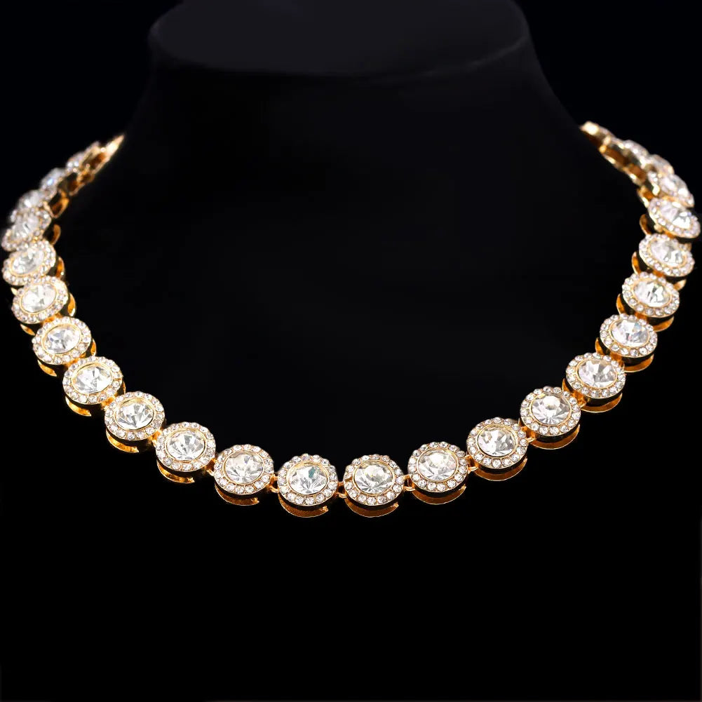 Raccourci de collier de tennis en strass doré sur un socle velours noir.