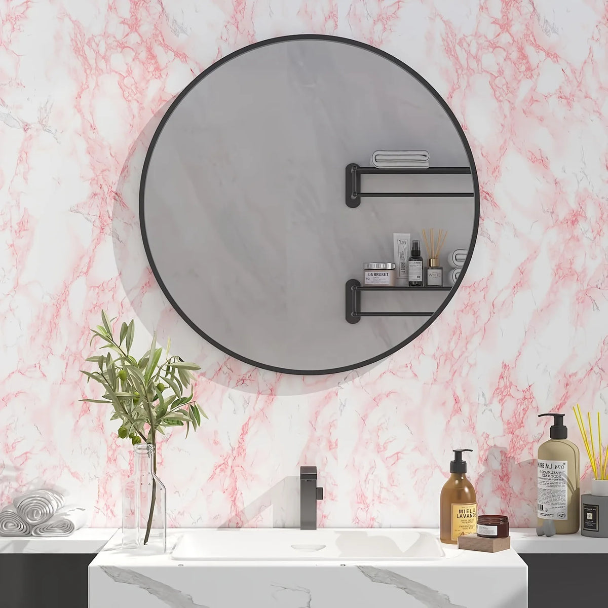 A bathroom vanity featuring a round mirror with black frame, marble countertop, and toiletries.
