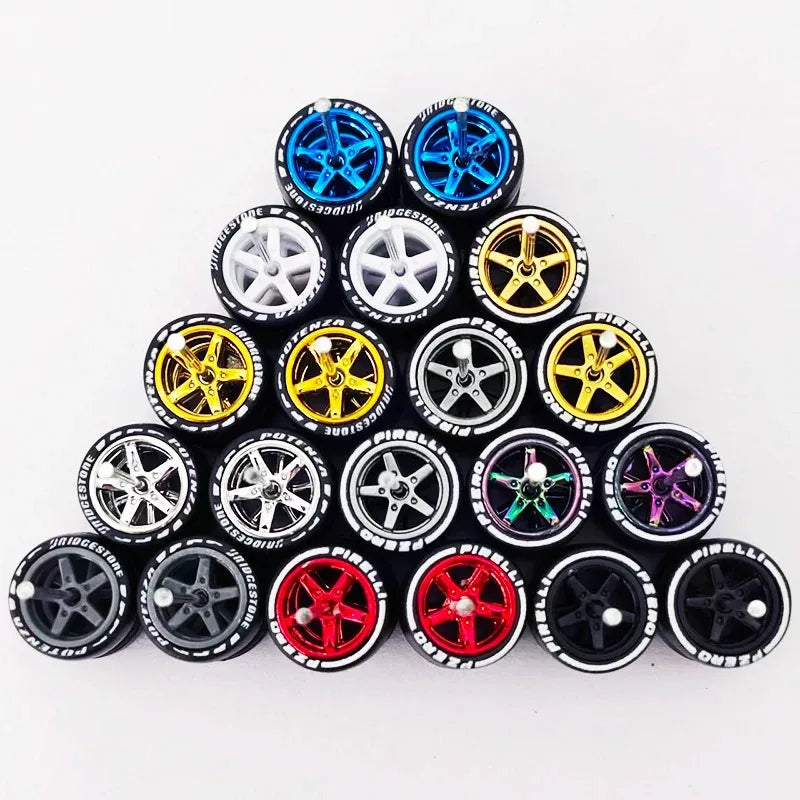 A collection of ten pairs of 1:64 scale alloy car wheels and tires in various colors including blue, gold, silver, and black.