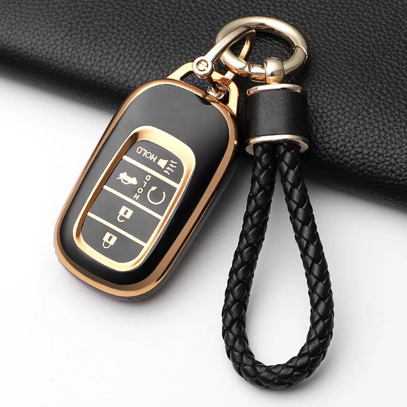 A black anti-scratch TPU protective case for a Honda key fob, attached to a gold-colored metal ring.