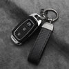 A black carbon fiber car keychain with an alloy buckle attached to a leather strap.