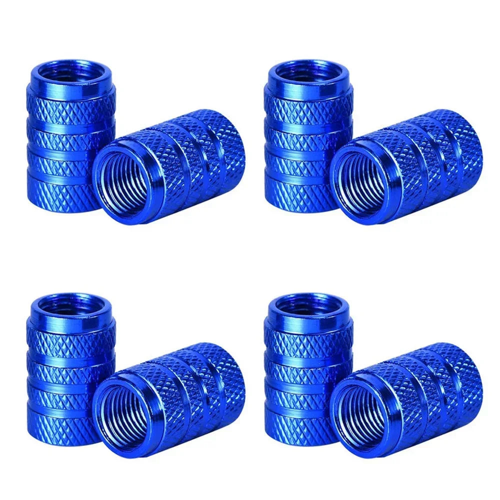 A set of four blue knurled aluminum tire valve caps shown in various angles.