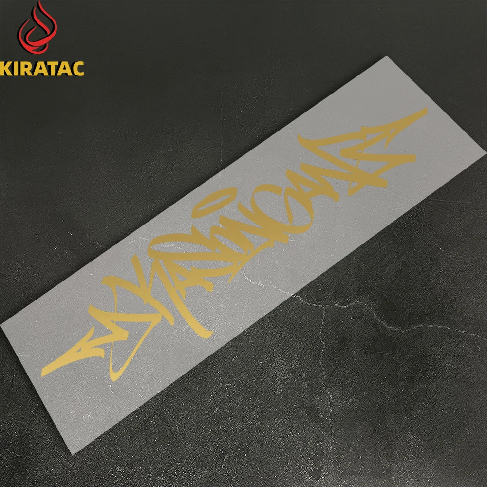 A silver motorcycle helmet sticker featuring yellow wildstyle graffiti text on a dark background.