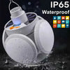 A white foldable solar camping lantern is shown with water splashing around, highlighting its waterproof IP65 rating.