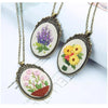 A set of three floral embroidery necklaces featuring purple, yellow, and pink flowers on beige fabric.