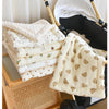 A stack of white and cream padded fabric cushions for a baby stroller seat with a folded cushion in the foreground.