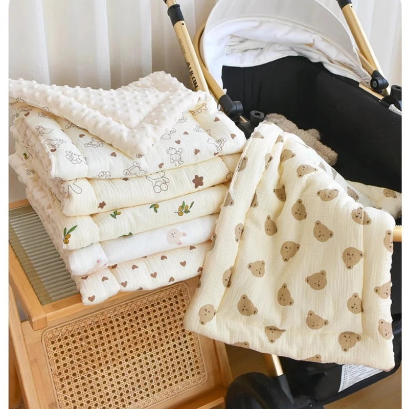 A stack of white and cream padded fabric cushions for a baby stroller seat with a folded cushion in the foreground.