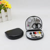 A portable mini sewing kit with various needles, scissors, and tools is displayed next to a small black case.