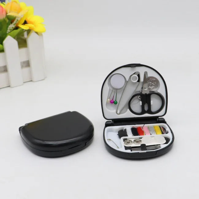 A portable mini sewing kit with various needles, scissors, and tools is displayed next to a small black case.