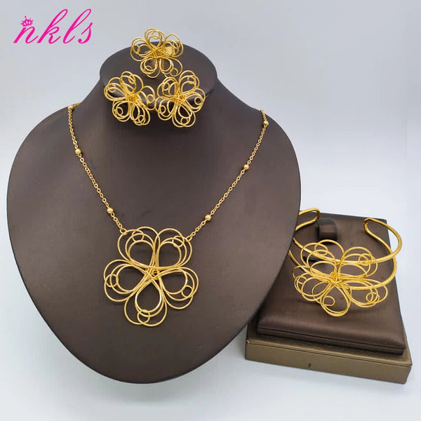 Juego de joyería floral chapada en oro para mujeres con intrincados diseños de alambre y pendientes, exhibidos en un soporte 