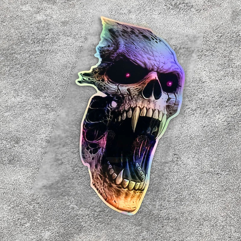 A detailed vinyl decal of a skull with glowing purple and green accents on a gray background.