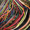 A close-up of a bundle of multi-purpose paracord ropes in various colors and textures.