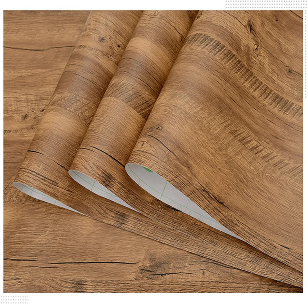Rolls of self-adhesive wood grain waterproof wallpaper showing the texture and finish.