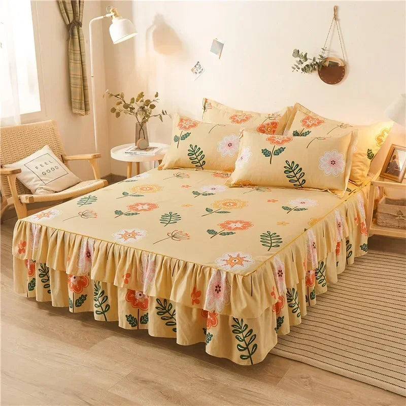 Un lit avec une couette imprimée jaune et une jupe froncée à motifs floraux.