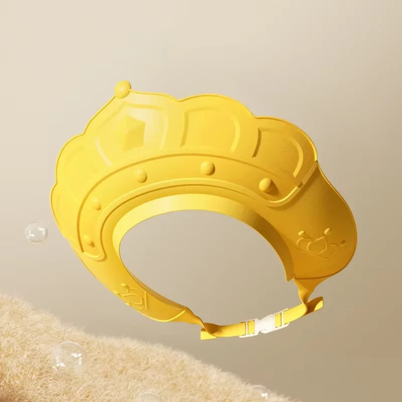 A yellow adjustable baby bath shampoo shield cap with ear protection is shown against a light background.