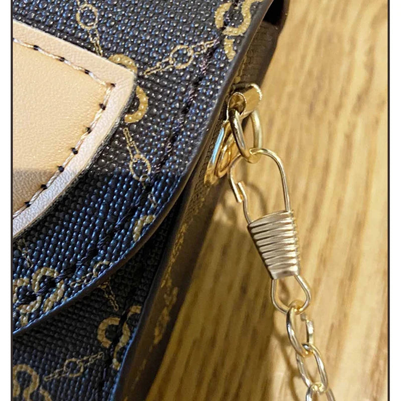 Close-up of a navy blue textured crossbody bag featuring gold chain detailing and a light tan leather flap.