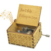 A vintage hand-cranked wooden music box plays the song Can't Help Falling in Love.