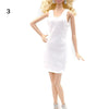 A fashion doll wearing a white, sleeveless mini dress and gold earrings.