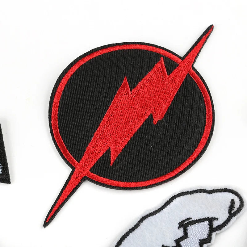 A black circular patch with a red lightning bolt design on a white background.