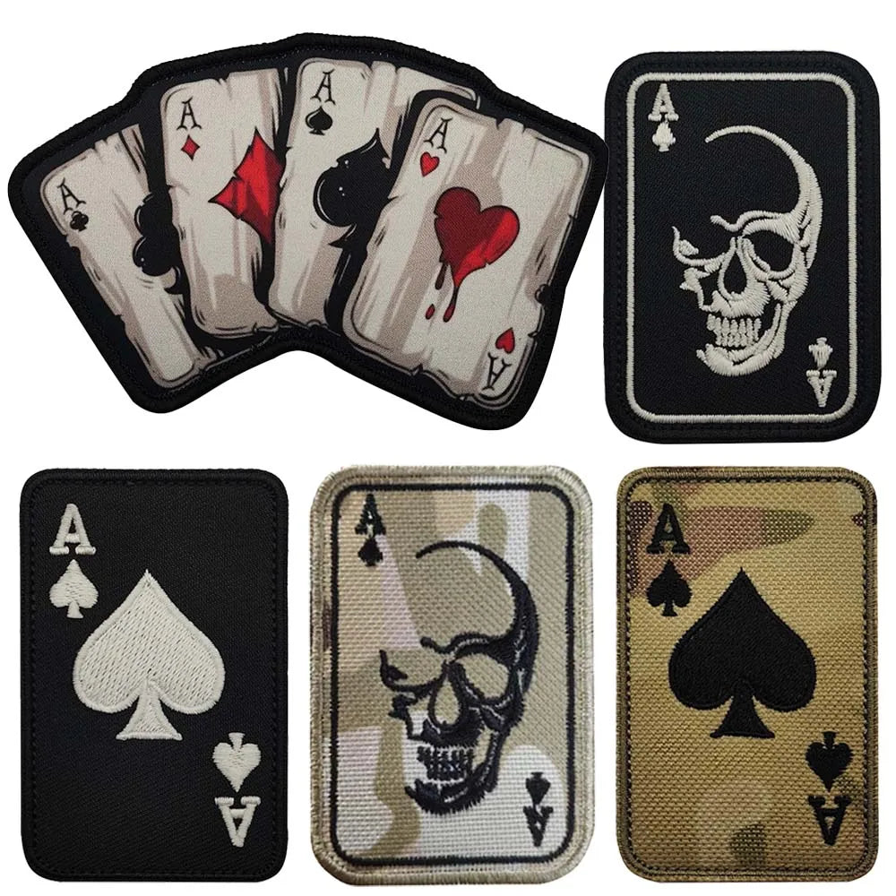 An embroidered patch featuring an ace of spades and a skull design with hook and loop backing.