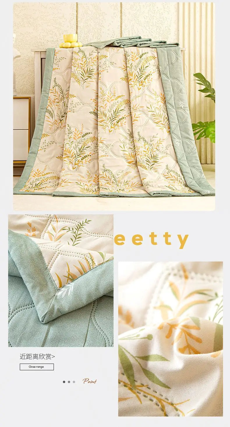 A stack of light green and beige quilted fabric featuring a delicate gold botanical print.