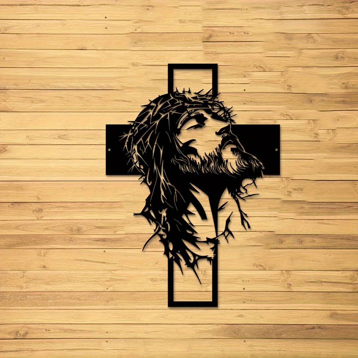 Silhouette noire de la tête et de la barbe de Jésus avec une croix sculptée dans un fond en bois.
