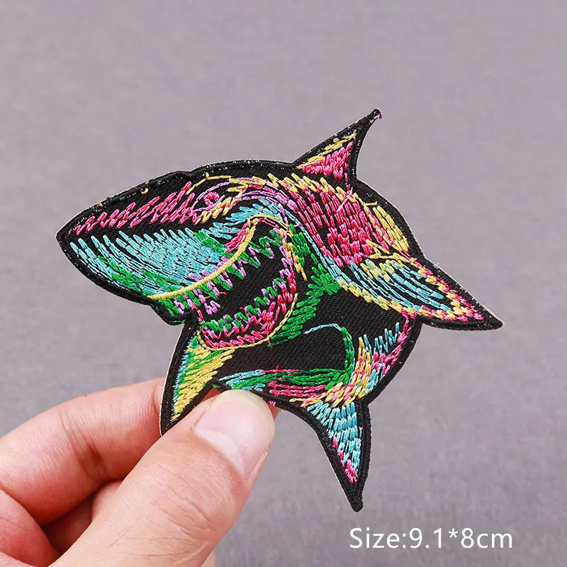 Embroidered skull horror patch featuring vibrant pink, green, and black threads on a dark fabric.